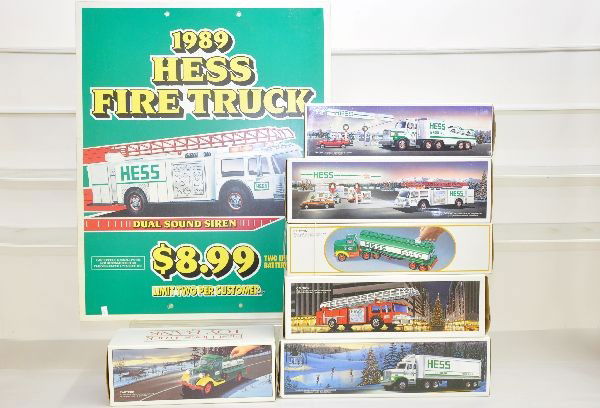 Hess Truck & Sign Lot: 6 Assorted Trucks from 1983 to 1989, plus an original gas station display sign from 1989, all appear new in box, sign shows light wear, C8-9