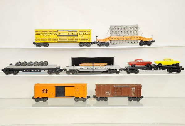 7 Lionel Freight Cars: 6356 stock car; 6464-725 NH boxcar; 6454 NYC boxcar; 6424 auto-loader; 3361-55 log dump with bin; 6262 wheel car, used load 6519 Allis-Chalmers car, 1 repaired brake wheel, otherwise all show light to