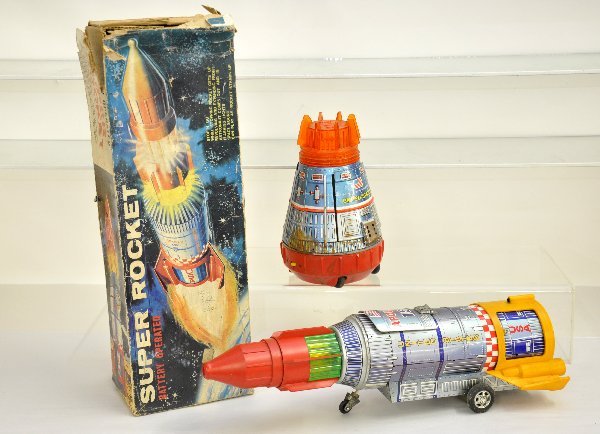2 Battery Op Space Toys: KY Japan Super Rocket, 16" long, missing battery cover, clean with rough original box; SH Japan Space capsule, some battery damage. Both are tested & show moderate playwear. Examine photos or call for