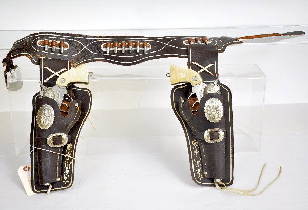Wyatt Earp Cap Gun & Holster Set: By Buntline, includes a pair of functional cast embossed pistols with a matching leather holster set. Shows light to moderate playwear. Examine photos or call for more information at 203 730-1404.