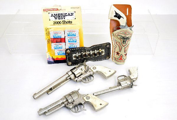 Vintage Hubley Cap Gun & Caps Lot: Includes Cowboy 45, needs spring; Texan Jr & Rodeo, both need adjustments; unnamed gun & holster; Holster bullet string piece & a box of TootsieToy caps. All otherwise show light to moderate playwear.
