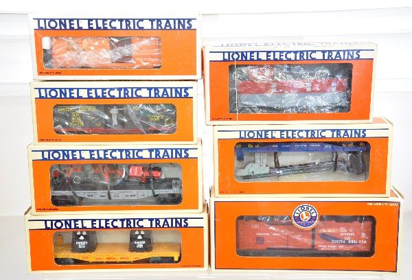 7 Lionel Freight Cars: 19808 ice car; 19821 operating boxcar; 16680 cherry picker; 16907 flat with tractors; 17606 smoke caboose; 16666 toxic waste car; 39236 boxcar. All are unrun with boxes, C9