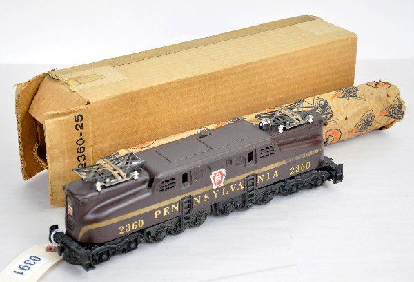 Scarce Boxed Lionel 2360 PRR GG1: Tuscan with single rubber stamped stripe and scarce uneven ventilators. It has great patina with a couple of minor lower edge chips. The decals are 99% with wrapping, ob & insert. It shows light playw