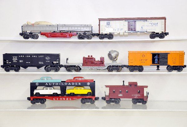 7 Lionel Freight Cars: 6672 reefer; 6414 auto-loader; 6456 hopper; 6520 searchlight; 6357 caboose; 3464 SF Oper. Boxcar; 3359 double-dump car with coal. All show moderate playwear, C6-6+