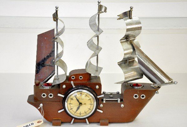 United Art Deco Ships Clock: Wood & tin, 20"x16". Electric clock works as does the interior lighting and the red sail lights, Bezel ships wheel missing 1 spoke, otherwise has a great look and shows light signs of use and age. Exa