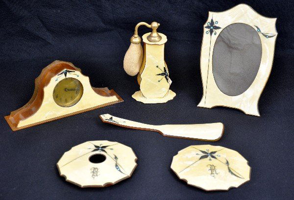 Art Deco Celluloid Dresser Set: Includes a 7" mantel style clock; 5" atomizer; 6 1/4" picture frame; 7" shoe horn & the tops only to a hair collector & powder box. All are in super condition with wonderful inlay. Examine photos clos