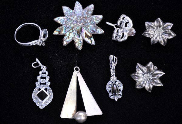 8Pc Sterling Silver Jewelry Group: Includes a 1 1/2" sail boat pendant; Mother of Pearl star pin; pair flower earnings; Marcasite ring; theatrical mask pendant, Crystal broken; 2 pretty marcasite & onyx pendants. All show signs of use