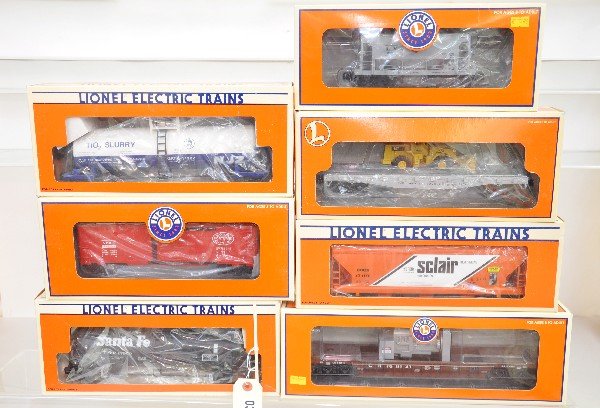 7 Lionel Freight Cars: 17902 tank car; 17107 hopper; 26028 well car; 39212 boxcar; 19348 ore car; 17517 flat with front loader; 17900 tank car. All are like new, dusty with boxes, C8+-9
