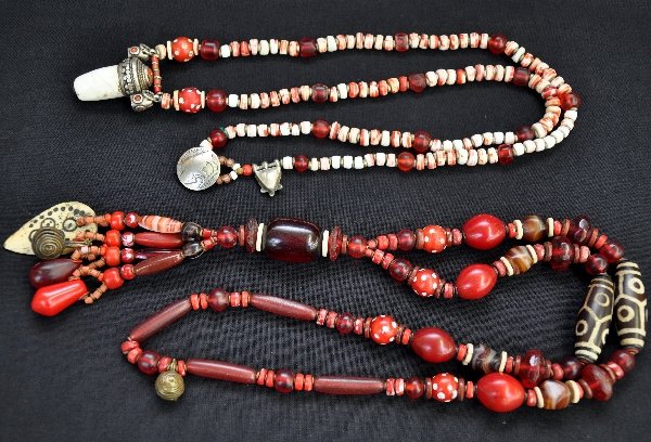 2 Unusual Vintage Necklaces: Both high quality and heavy. One is 28" with 7" tassel incorporating an ivory plate. Beads are glass, ivory with metal bells. Second piece is a 32" piece with sterling, Tibetan style ornaments with in