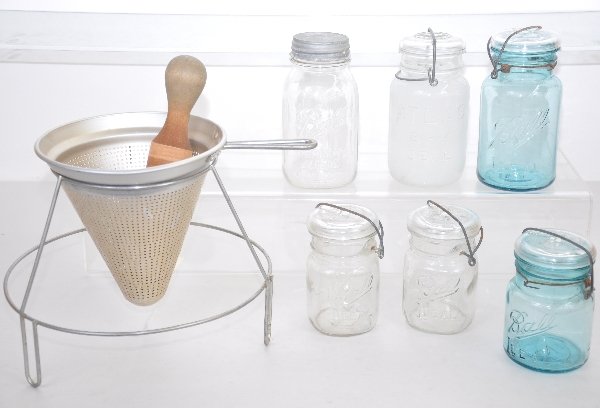 Vintage Kitchen Items: Aluminum cone strainer and wooden pestle set ; 5 Ball & Atlas canning glass jars, 2 are blue glass, plus 1 Ball tin top jar. All show moderate signs of use & age. Examine photos or call for more infor