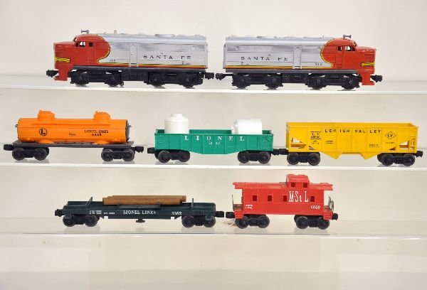 7Pc Lionel Diesel Freight Set: 212/215 SF Alco AA diesels, clean & intact; 6142 gondola with canisters; 6465 tank car; 3362 helium tank unloader; 6076 hopper; 6059 M&StL caboose. All show light playwear, C7+