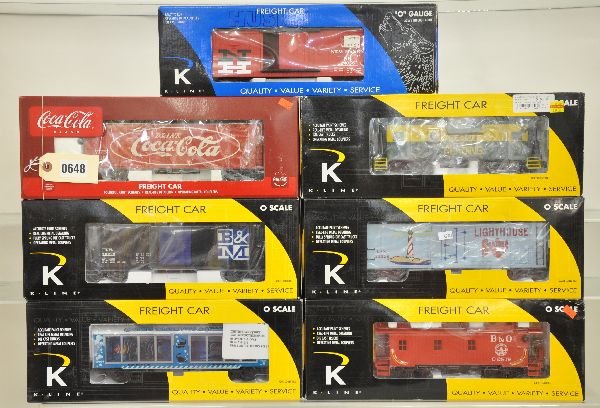7 Deluxe K-Line Freight Cars: K613-1933 smoke caboose; K762-8034 reefer; K616-1091 smoke caboose; K761-1132 boxcar; K762-5104 Coca-Cola reefer; K704-2004 aquarium car; K646-1791 boxcar. All show light runtime with boxes, C8+-9