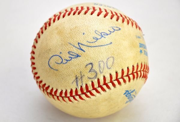 Signed Phil Niekro Baseball: Rawlings game ball, with an original Phil Niekro signature in the curve-ball spot in blue ball point pen. It has #300 below signature in different pen. Signature is strong and ball shows playwear. Exa