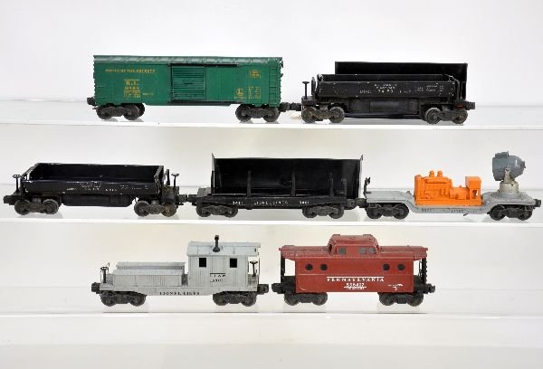 7 Lionel Freight Cars: Includes 3459 coal dump with bin; 3461 log dump, no load; 6419 work caboose; 6417 N5c caboose; 3520 searchlight, no lens; 6464-75 RI boxcar, type I; 3469 coal dump with bin. All show light to moderate