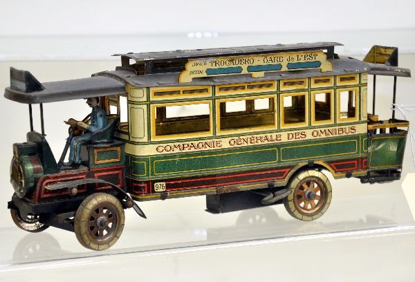 Unusual Jep Trocadero Omnibus Toy: 11 1/2" long, litho tin with driver. Mechanism is functional with position steering. Body litho is fairly clean with nice detailing, roof plating is almost gone. Scarce single axle variation, otherwis