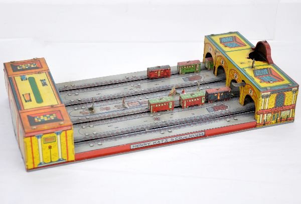 Henry Katz Grand Central Station: 16" long, tin litho platform toy. Dual action functional with light assistance. The litho is clean and appears complete with small pieces in center. It shows light to moderate playwear, C7