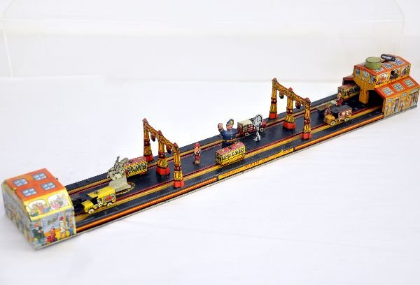 Marx Main Street Wind-up Toy: 24" litho tin, mechanism functions, though string slips. Includes 6 vehicles and all accessory pieces are intact. The litho is rich in color and it shows light playwear, otherwise C7-7+