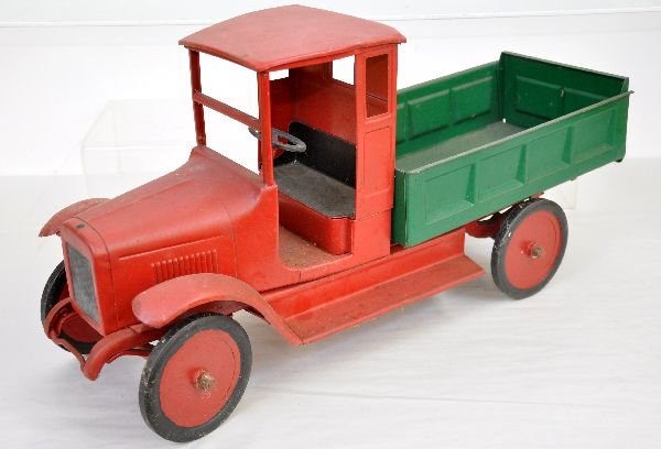 Early Buddy L Utility Truck: 25" long, painted pressed steel, circa 1920s. Closed cab with steerable turned metal wheels. It has a stationary bed with opening rear gate. It is an old repaint, but done nicely, This may be a compos