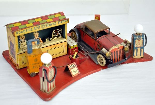 Deluxe Marx Roadside Rest Service Station: 17" litho tin platform with 2 illuminated gas pumps, bulbs incorrect. Has replaced hoses, no nozzles; Oil cart; diner with clean battery box, Illuminated lift & free Air pump. The vehicle is tin with 