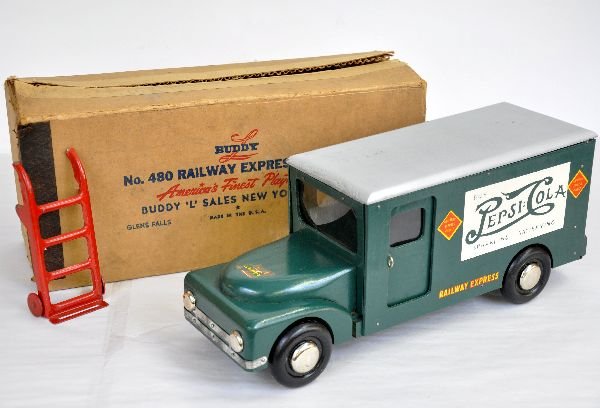 Boxed Buddy L 480 REA Truck: Circa 1943 war production. Painted wood with Pepsi-Cola ads on sides. It includes the original handtruck with wrapping. It shows very light wear with a nice box, C8-8+