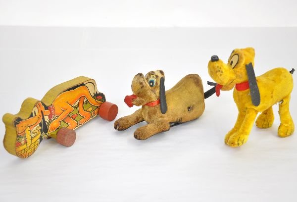 3 Vintage Disney Pluto Toys: Line Mar plush whirl tail Pluto with paper label; Begging, roll-over Pluto style toy, stained; Scarce black label Fisher Price Pluto. All show moderate playwear, C5-6