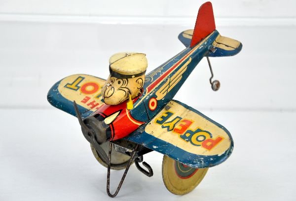 Marx Popeye the Pilot: Scarce Popeye Toy. Litho tin with 7" wing span. Crazy car action functional. It has some bending to wings and shows moderate playwear, C6-