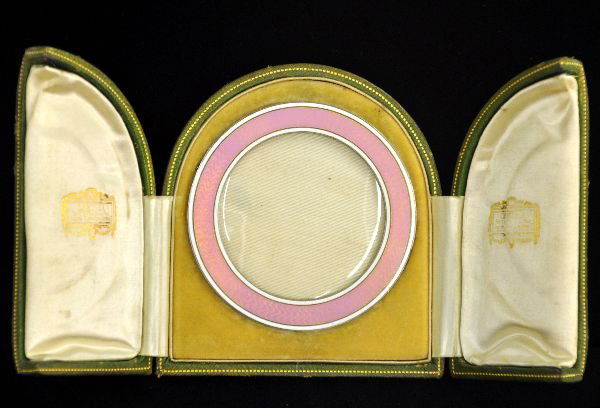 Fantastic Cartier Enamel Frame: Circa 1930s, 3 3/8" Art Deco pink enamel with white border on copper frame with ivory back. Stand needs reattaching, but frame shows light wear with wonderful tooled leather display box. Ivory back is