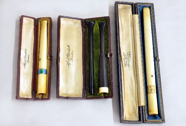 3 Dunhill Ivory Cigarette Holders: Includes 6" holder with gold floral inlay; 4" Ivory holder with painted enamel ring, tip has crack; and a 4"/6" two pc set with ebony Bakelite handles with Ivory tip. All show signs of use & age with