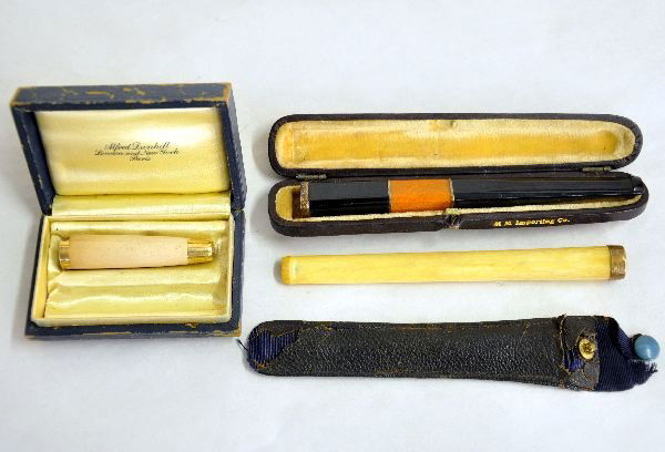 3 Unusual Cigarette Holders with 14K Gold Tips: Includes a 5" ebony & amber deco holder with hard case, marked MM Importing; 5" ivory holder with worn leather pouch; 2 1/4" Dunhill holder, Meerschaum with gold tips & worn hard case. All tips stampe