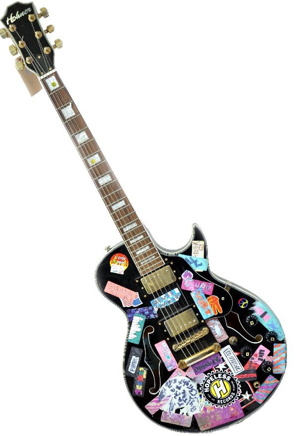 Hohner HJ4-TBL Semi-Hollow Body Electric Guitar: Electric guitar comes in a black gloss finish, bronze plated hardware and components. Mother of pearl fretboard inlays. Majority of the body has been covered in vintage stickers. Guitar shows moderate