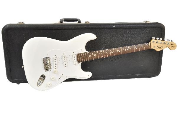 Fender Squire Bullet Series Stratocaster: S/N NC405233. White finish with white fret board. Guitar has moderate play wear along with checking and contusions in finish. Fretboard still has protective plastic lining. Neck appears to be true. Fr