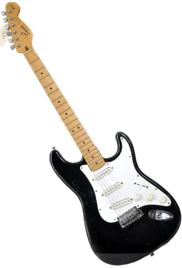 Fender Squire Stratocaster: S/N MN315971. Guitar is in a black gloss finish with white fretboard. Has numerous gashes in finish, along with shallow surface crack along back of body. Considerable fret wear. All knobs appear to be