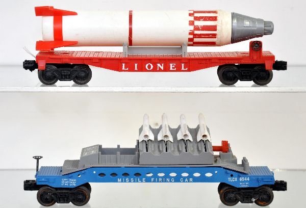 Lionel 6407 & 6544 Space Cars: 6407 flat with rocket. Trim marked Sterling with sharpener in nose, rocket shows wear, (C5+); 6544 Missile firing car with white panel & 4 missiles. It has one intact brake wheel. Otherwise flat cars 