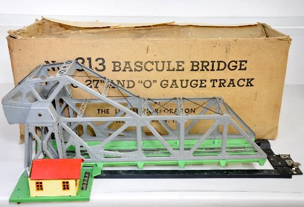 Boxed Lionel Bascule Bridge, Gray: 1942 production with a 92 gray super structure. The base casting is slightly warped and has its brace/alignment piece. It is missing the light cap and has its rough original box with 1 insert. It show