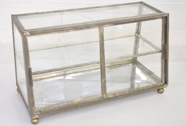 Vintage Counter Top Glass Display Case: Cute 1950s style chrome & glass display case. Measures 18X9X11" with slant front opening doors. The top pane is cracked and the chrome is pitted from use, but makes a nice display for diecast cars and