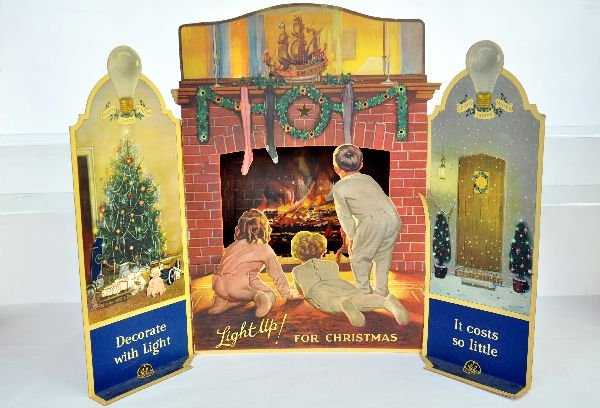 Vintage GE Fireplace Christmas Display: 33X24X3 1/2" paper litho on cardboard display. Fire place is 3 dimensional and has a place for lights. The mantel has openings with colored inserts that are very pretty when lit up. The wings have bee