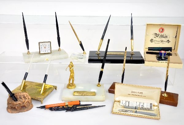 Nice group Of Dip Pens, Several 14K tips: Includes 7 desk sets, one plated Riverside Golf Club 1955; one has a Lucite base with 1 1954 silver half dollar encased; One has a marble base with non working Florn alarm clock. Also a Schaeffer dip 