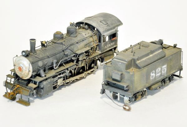 Boxed Samhongsa HO Brass 0-8-0 Steam Locomotive: Lettered AT&SF #825. It has been professionally painted & decaled. It has super detailing, tender is equipped with a back-up light. Shows light runtime with Sunset box. They show very light signs of w