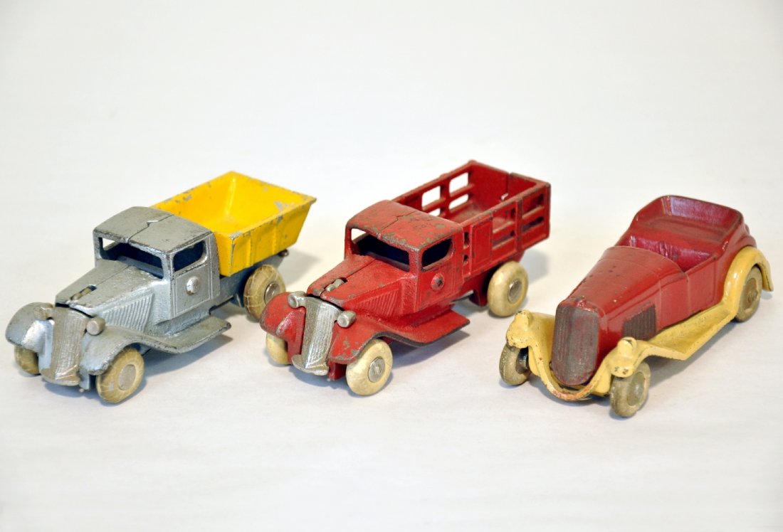 3 Nice Arcade Cast Iron Take-Apart Vehicles: Each is 4 1/2" long with white rubber hubbed wheels. Includes a stake truck, dump truck & roadster. They are clean & shiny, showing light to moderate playwear, C5-7