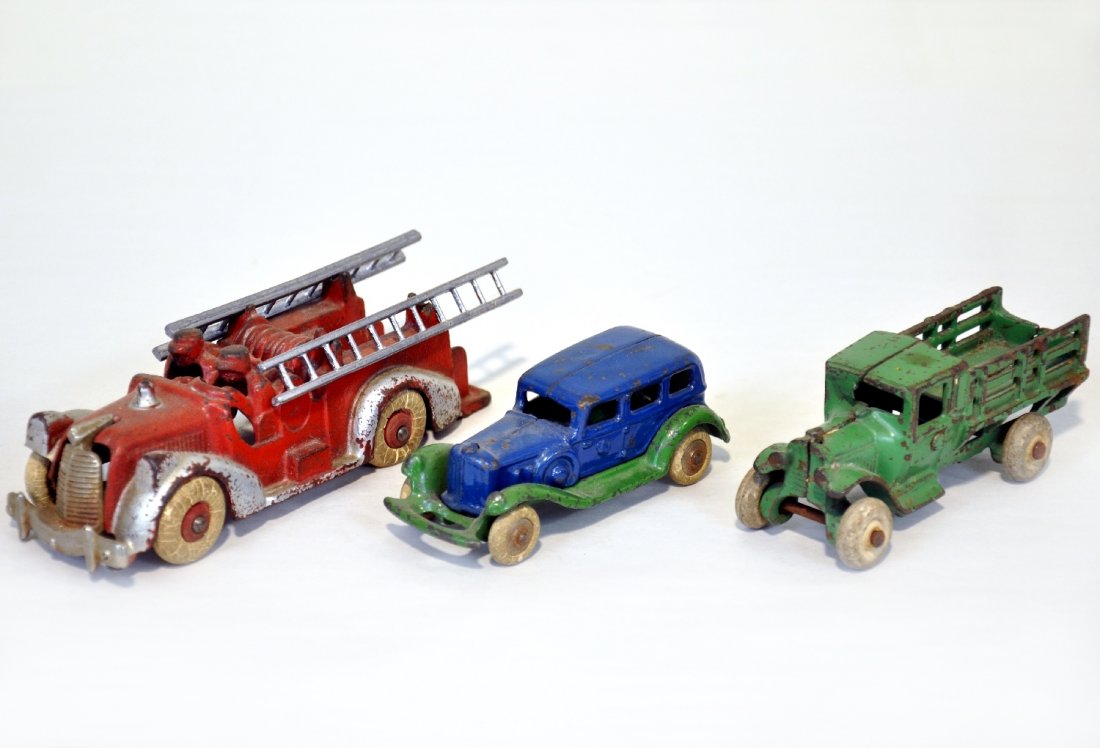 3 Cast Iron Vehicles: Includes a 5" Hubley stake truck, C5; AC Williams take-apart sedan, C6, and a 6" Hubley ladder truck with original ladders, but has a broken front fender, paint is C4