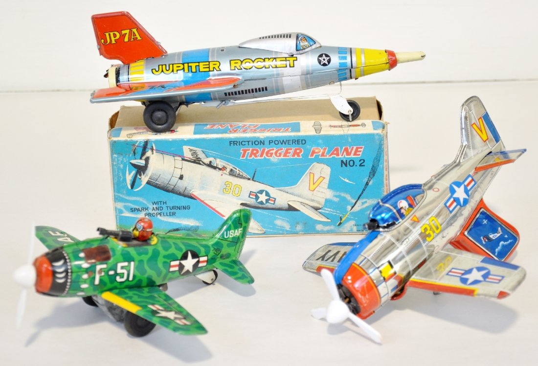 3 Japanese Tin Airplane Toys: Includes a boxed Litho tin 8" TN Trigger Plane; Masuya Jupiter Rocket, friction with stand-up action when it strikes a barrier; SY Japan, F-51 fighter, friction drive. All show light to moderate playw