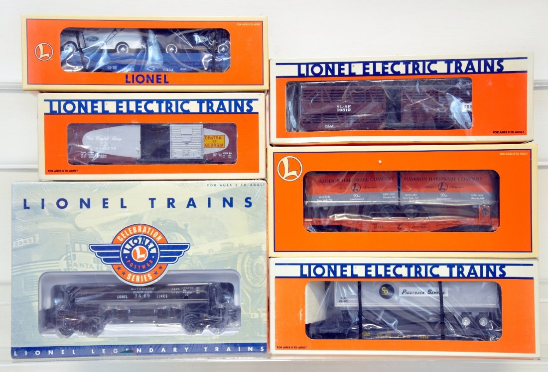 6 Mint Lionel Freight Cars: 6424 Flatcar w/ Ford Panel Trucks 16985, Frisco Stock Car 19519, Central of Georgia Boxcar 19279, C&O Flatcar 16398, Madison Hardware Flatcar 52187 and Lionel Line Coal Dump Car 36740. These cars are