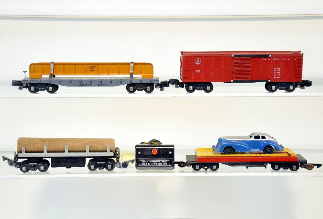 4 American Flyer Freight Cars: S Gauge. Includes a 715 unloading car with Manoil roadster & controller; 714 operating lumber car; 633 boxcar with knuckle couplers; 627 girder car with knuckle couplers. All are clean, showing light 