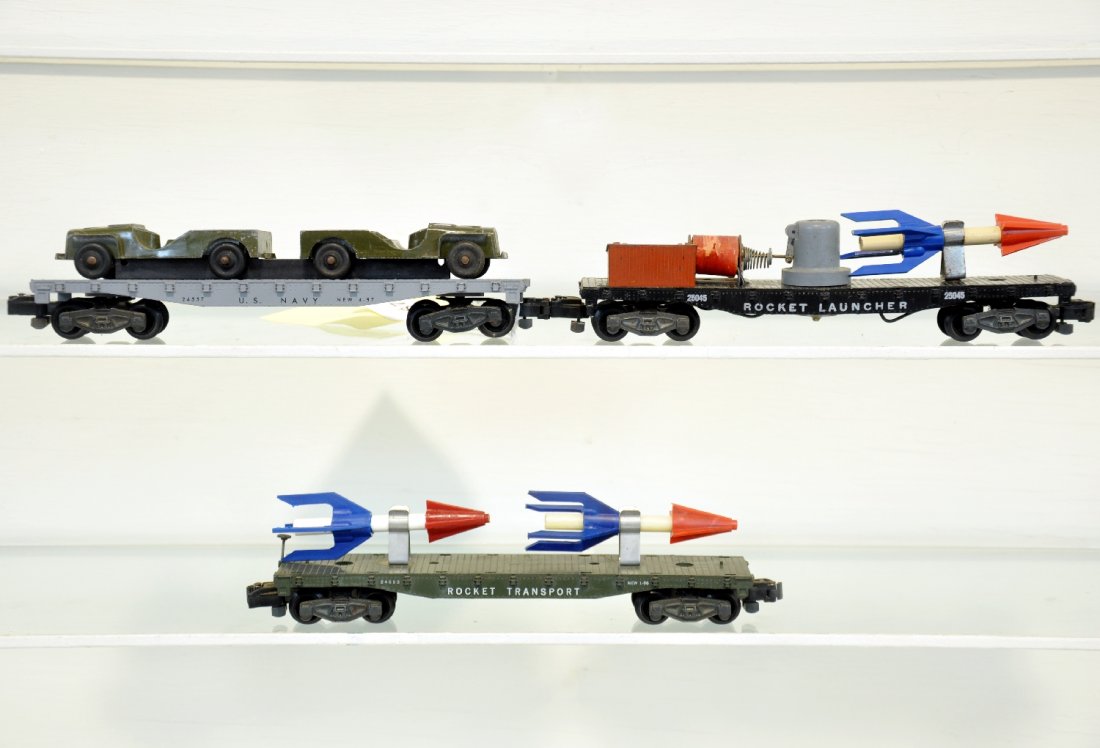 2 American Flyer Military Freight Cars: S Gauge. Includes 25045 Rocket launcher; 24557 Navy flat with Tootsie Toy jeeps; 24553 flat with rockets. All show light to moderate playwear, C7