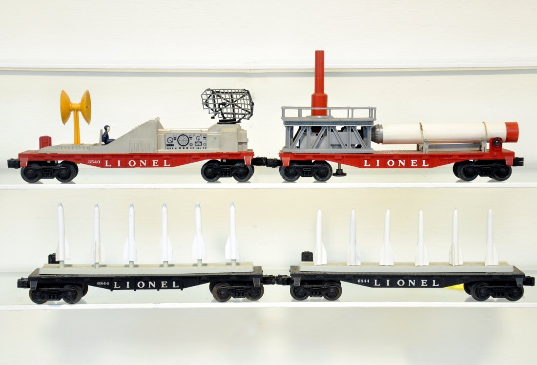 4 Lionel Military Cars: Includes 2 #6844 missile carrying cars; 3540 radar car, replaced figure; 3513 Mercury Capsule Launching car, complete with parachute, railings intact, small split in rocket. They show light to moderat
