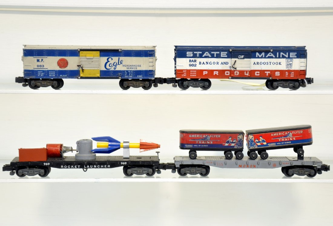 4 American Flyer Clean Freight Cars: S Gauge. Includes 969 rocket launcher; 983 MP boxcar; 953 SOM boxcar; 956 flat with trailers. All show light to moderate playwear, C7
