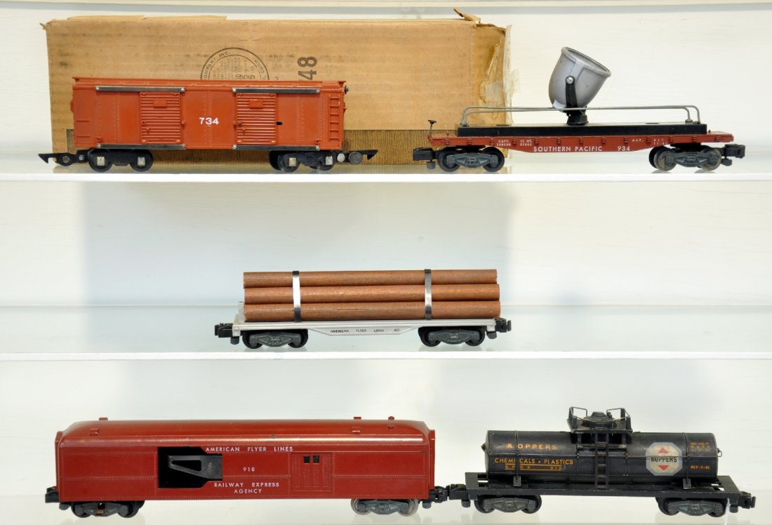 5 American Flyer Freight Cars, 1 Boxed: S Gauge. Includes a LN boxed 734 brown merchandise car, car only with wrap & box; 912 Koppers tank, C6; 905 log car; 918 operating mail car, car only; 934 searchlight. Otherwise all show light playwea