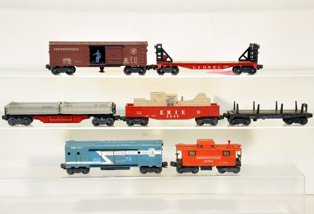 7 Lionel Freight Cars: Includes 3530 generator car, no pole; 3359-55 double dump car, car only; 3484 PRR operating boxcar; 2457 PRR caboose; 3451 lumber dump, car only; 6467 bulk head flat, no stakes; 3444 cop & hobo car, n