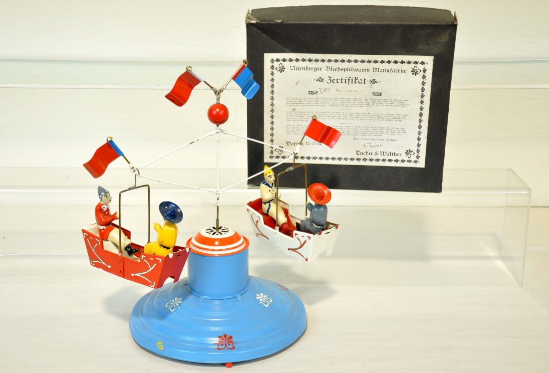 Tucher & Walther Merry Go Round: Super reproduction European Marklin style toy. Enamel tin with wonderful hand-painted details. It is 9" wide and appears new in box, C9-10