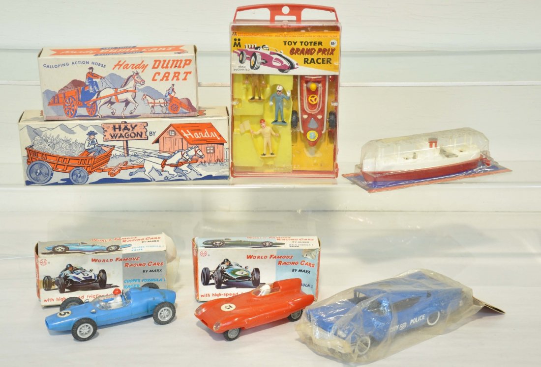 Assorted Vintage Plastic Vehicle Toys: Includes a boxed Hardy Hay Wagon & Dump Cart; Multiple Toymakers Grand Prix racer set in case; 2 Boxed Marx friction racers; 8" AMT 1958 Belair Police car, sealed in packaging; Lehmann Fortuna boat, s